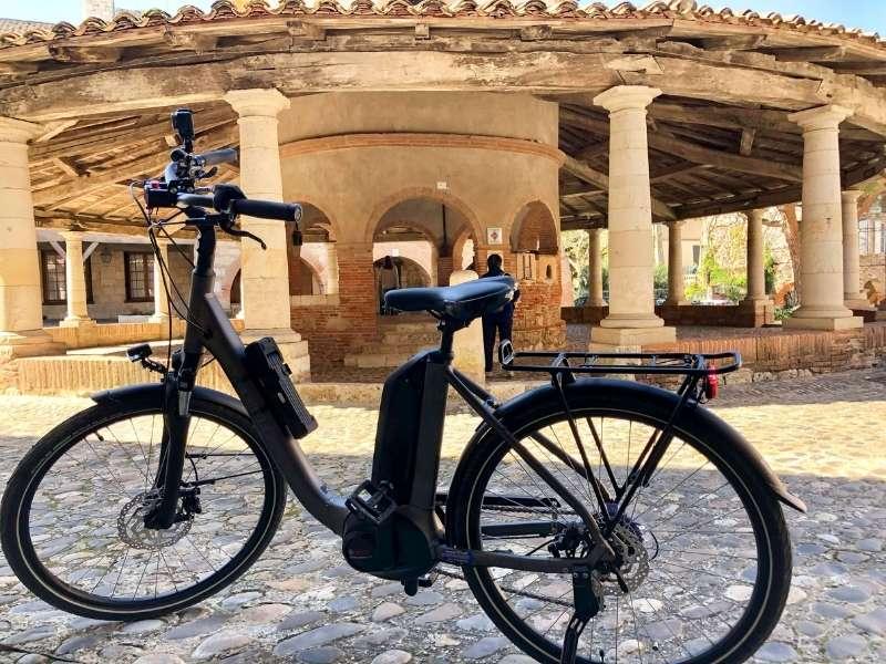 My electric bike in front of Auvillar's iconic circular covered market